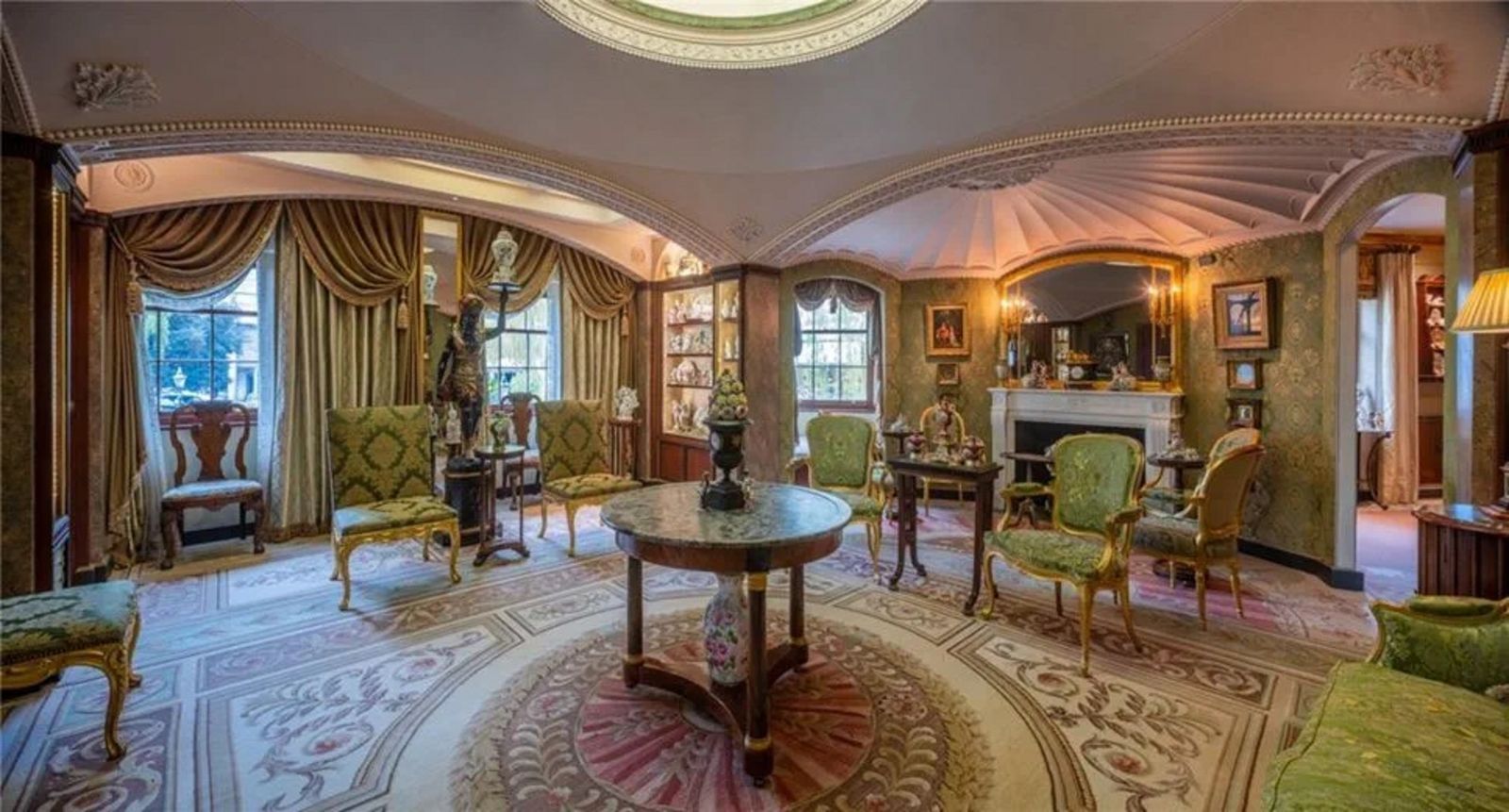 Antikes Wohnzimmer mit dekorativem Teppich, Vorhängen und grünen Stoffsesseln CHA240006_37.jpeg