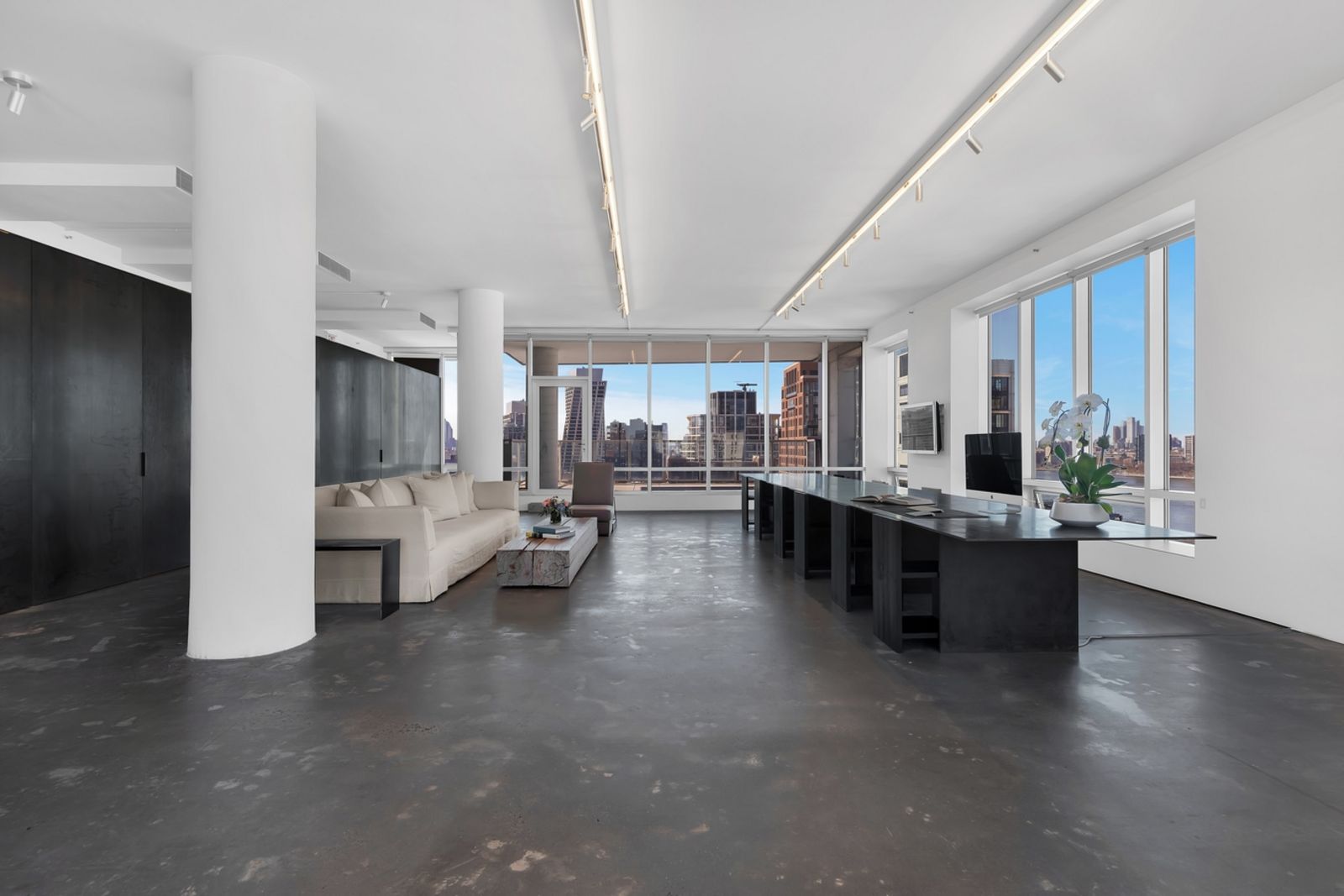großer Wohnbereich mit zwei Säulen und Sofa dazwischen Calvin_Klein_Penthouse_in_New_York_City__c__Anton_Brookes___H5_Photography__3_.jpg
