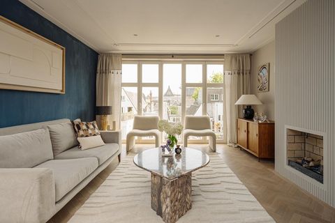 Design-Wohnzimmer in hellen Tönen mit edlen Holz- und Steinmaterialien sowie Panoramafenster mit Blick über die Dächer Amsterdams 245161074.jpg