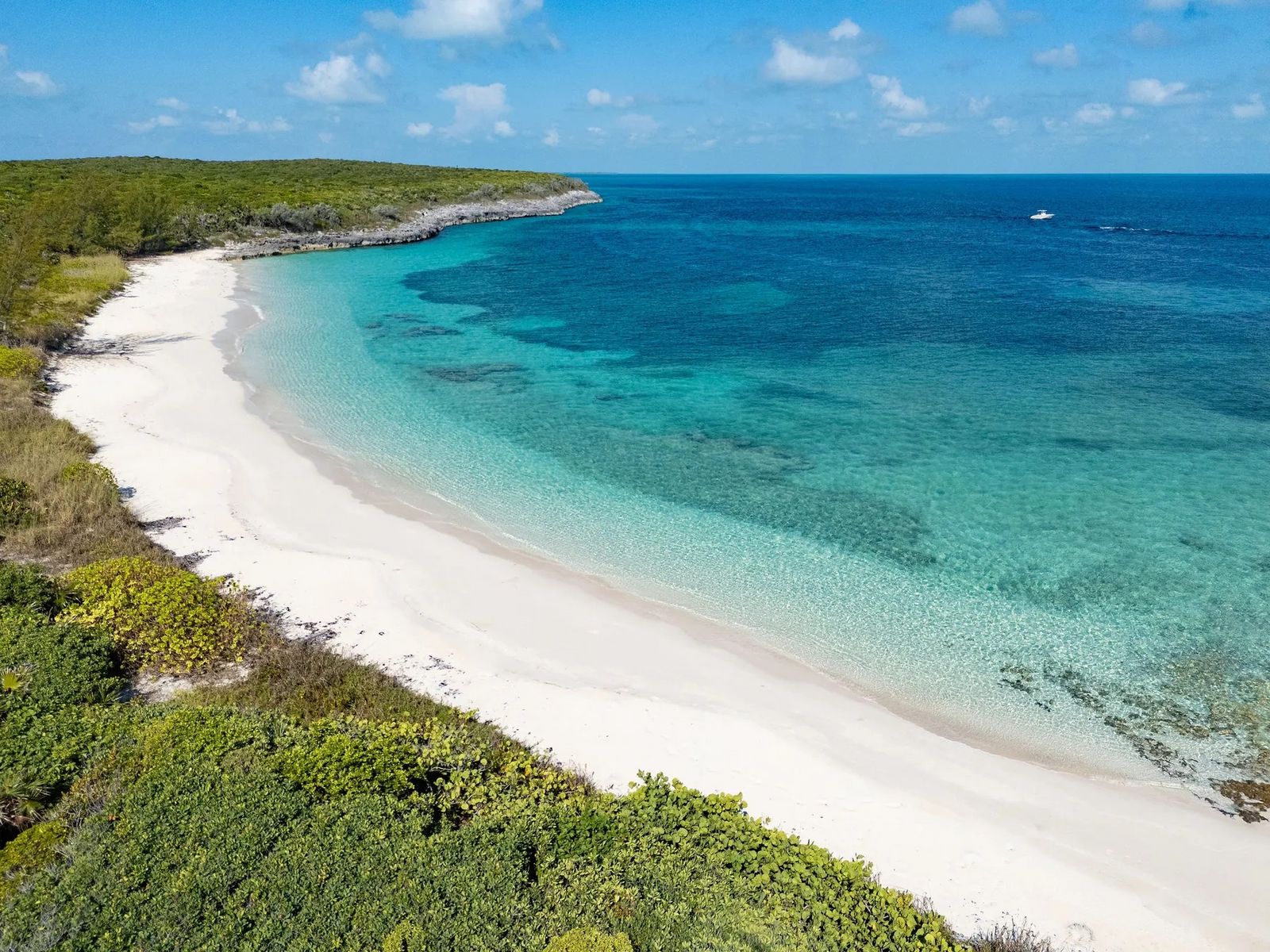 Weißer Sandstrand mit türkisblauem Wasser und grünen Bäumen entlang der Küste. D2A05E6C-35AB-45BB-A826-C37D92203766.jpeg