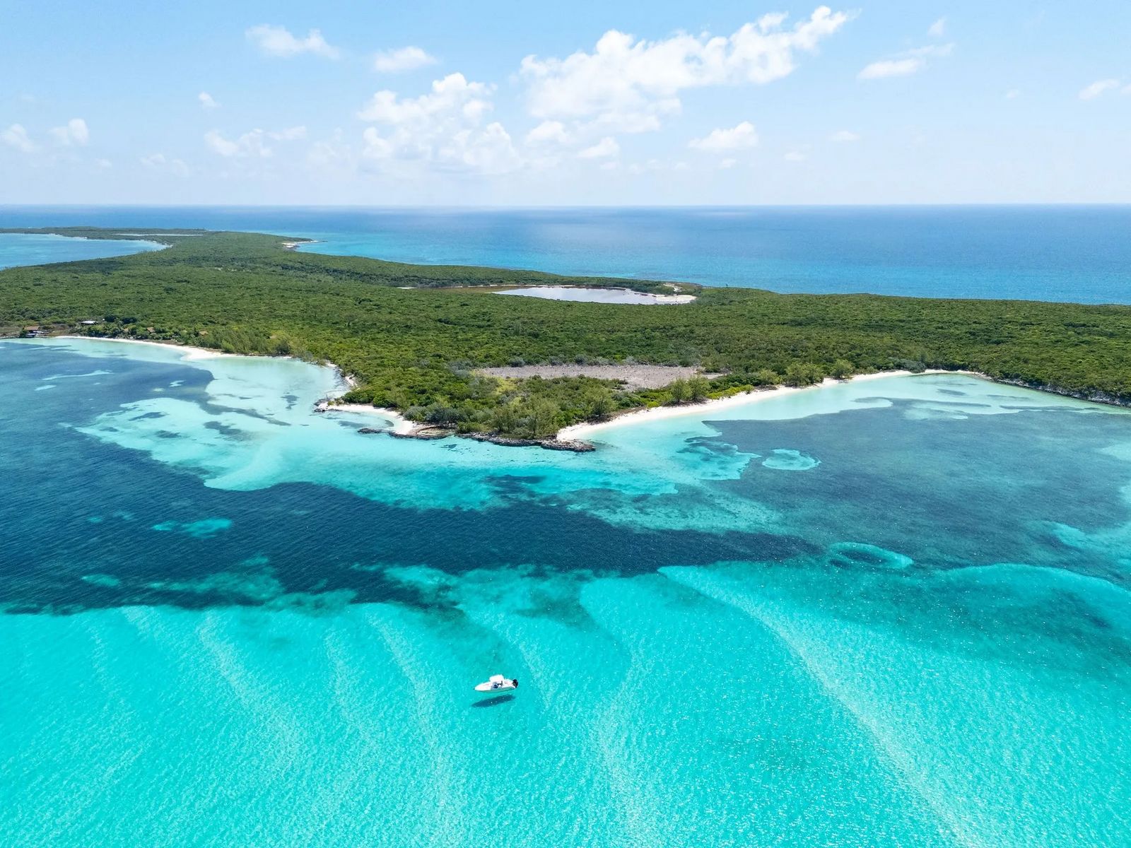 Türkisblaues Wasser mit kleinem Boot, aus der Vogelperspektive gesehen F6C4C17E-35BB-4F6E-B271-C38661034396.jpeg