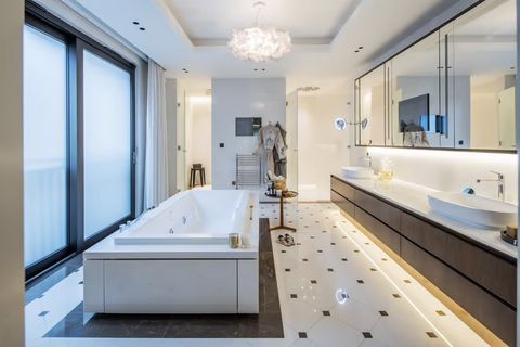 Modernes Wellnessbad mit freistehender Whirlpool-Badewanne, Doppelwaschtisch, großformatigen Spiegeln und indirekter Beleuchtung. ui45gksx6.jpg.jpeg