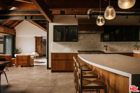 Maskuline Küche aus Marmor und Holz mit Rattanstühlen und sichtbaren Holzbalkendecken. origin5.jpg