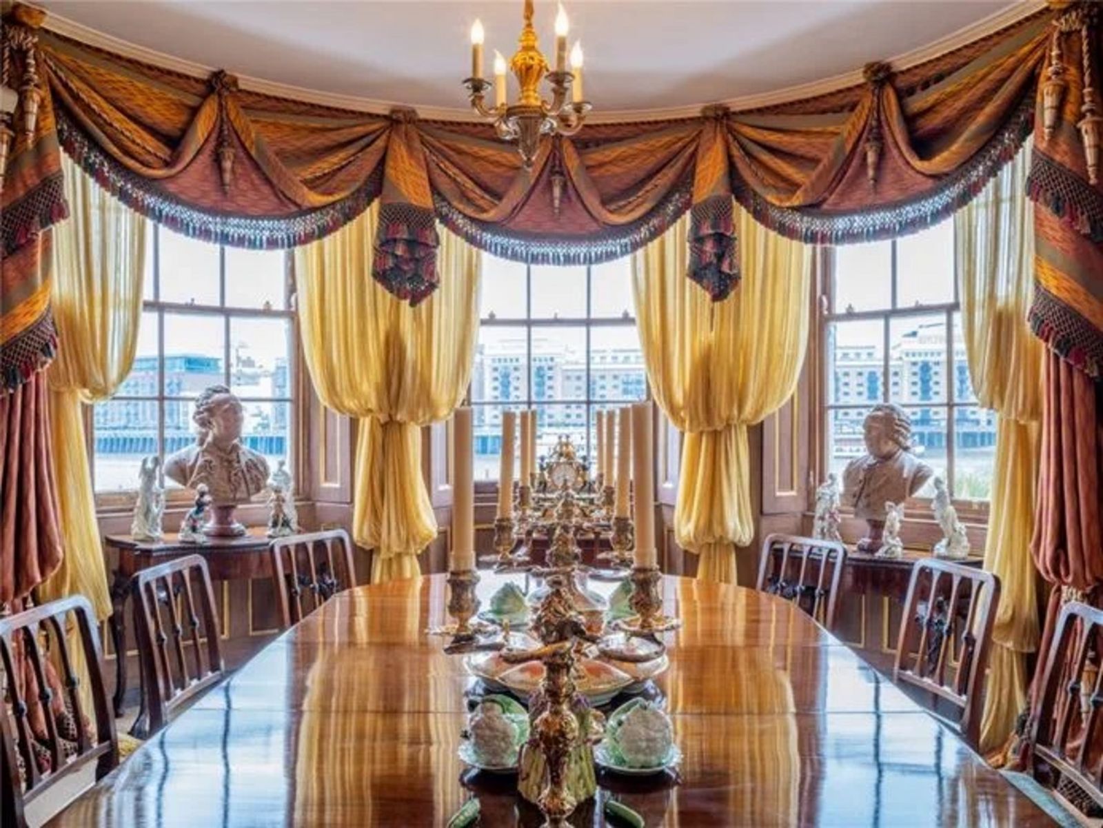 Antikes Esszimmer, vom Tisch aus gesehen, mit Blick auf die Außenfenster, üppigen Vorhängen und dekorativen Statuen CHA240006_11.jpeg
