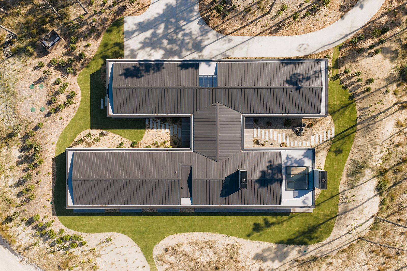 Luftaufnahme des Hauses mit zwei Flügeln, die durch einen zentralen Korridor miteinander verbunden sind. Te-Arai-Homesite-10.jpg