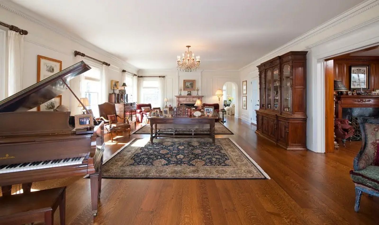 Wohnbereich hell mit dunklen Holzdielen, Teppiche, Kronleuchter, Flügel, Kamin 1388237-18.jpgx.jpg