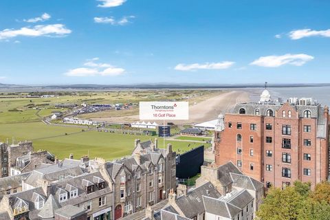 Blick über die Dächer von St Andrews auf den berühmten Golfplatz und die Küstenlandschaft dahinter. Im Vordergrund stehen historische Wohn- und Geschäftshäuser. 53151284.jpg