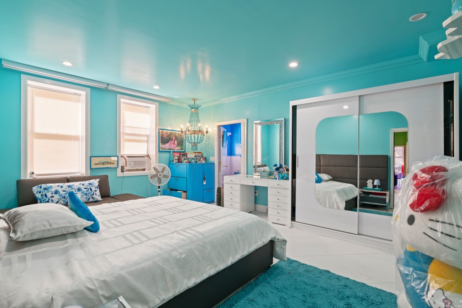 Schlafzimmer, weißer Boden und Schrank, Wände türkis, große Hello Kitty Figur 08_28-07_36th_Ave-Ground_Floor-Primary_Bedroom_A.jpeg