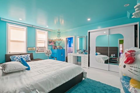 Schlafzimmer, weißer Boden und Schrank, Wände türkis, große Hello Kitty Figur 08_28-07_36th_Ave-Ground_Floor-Primary_Bedroom_A.jpeg