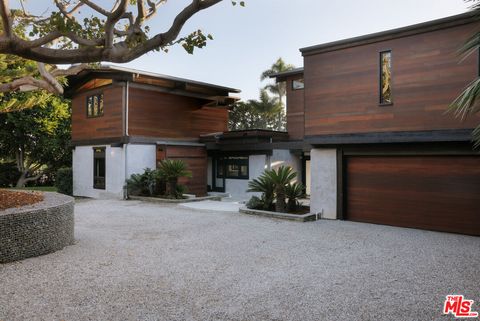 Hausfront aus dunklem Massivholz und grauem Marmor mit kleiner Kiesfläche vor dem Eingang. origin3.jpg