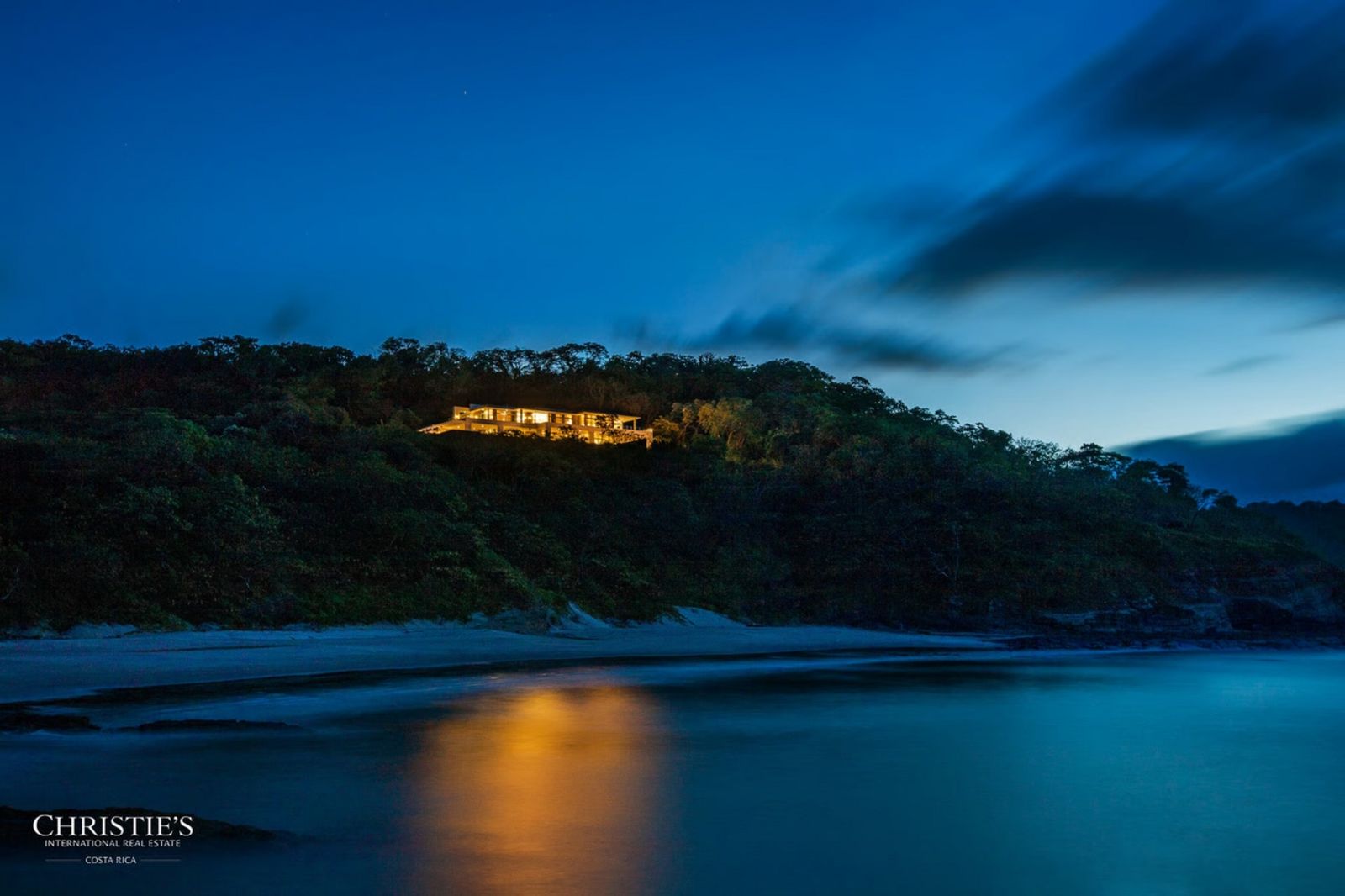 Abendstimmung über dem Wasser mit dem beleuchteten Haus in der Ferne cbaf5432-2802-45e3-a3fc-3967b9f86ace.jpg