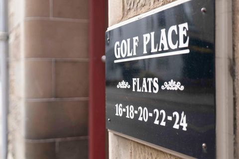 Schwarzes Gebäudeschild mit der Aufschrift „Golf Place Flats“ und den Wohnungsnummern 16 bis 24 an einer Steinfassade. 53151482.jpg