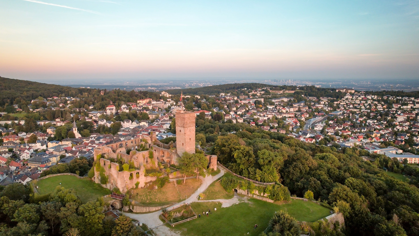 Aerial view over castle Königstein am Taunus to skyline of Frankfurt Main at horizon at sundown AdobeStock_467430801_Beautiful_aerials.jpeg