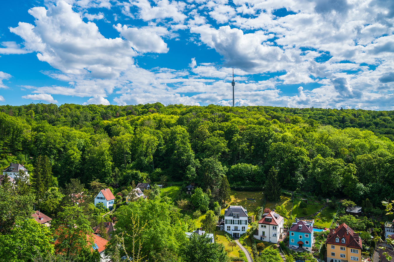 Luftaufnahme mit einzelnen Häuser am Wald, Fernsehturm in der Ferne 1350x900_Website_Tra__umeOrte_AdobeStock_450826924_Simon.jpg