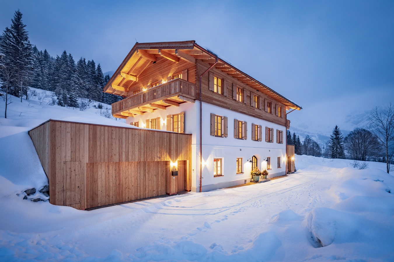 Ansicht einer Luxusimmobilie in abendlicher Schneelandschaft. AdobeStock_616136410_mRGB__1_.jpeg