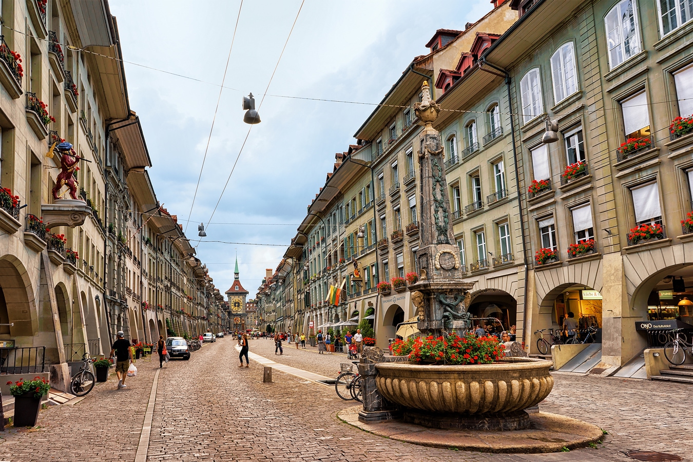 People at Kreuzgassbrunnen on Kramgasse street with shopping area in old city center of Bern, Switzerland AdobeStock_143283020_Roman_Babakin.jpg