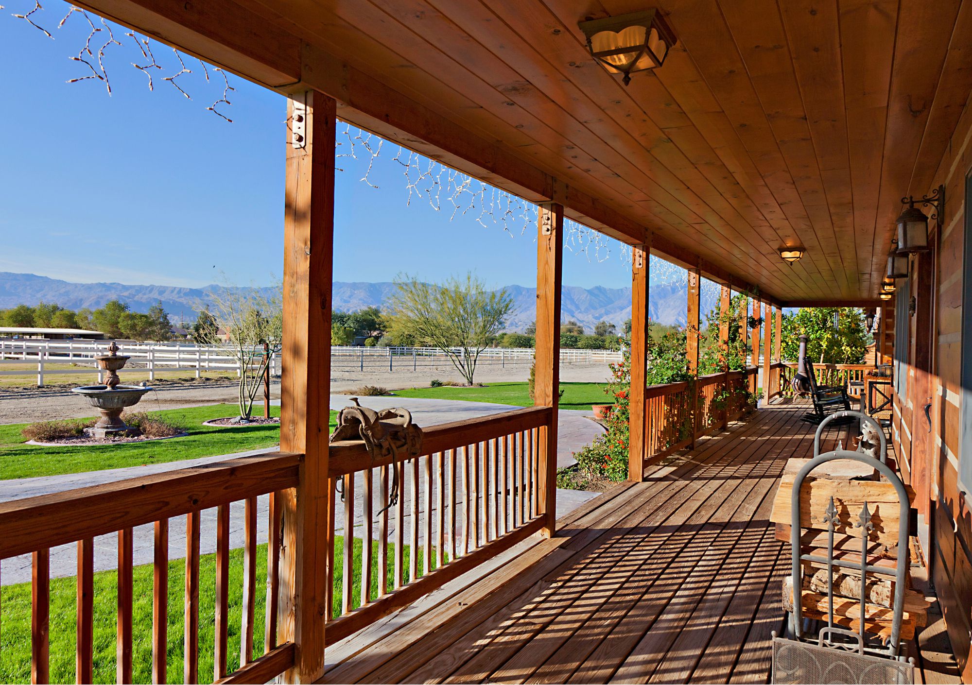 sonnenbeschienene Veranda mit Sattel, Blick auf Reitanlage ehorses_canva_DAPA_Images.jpg